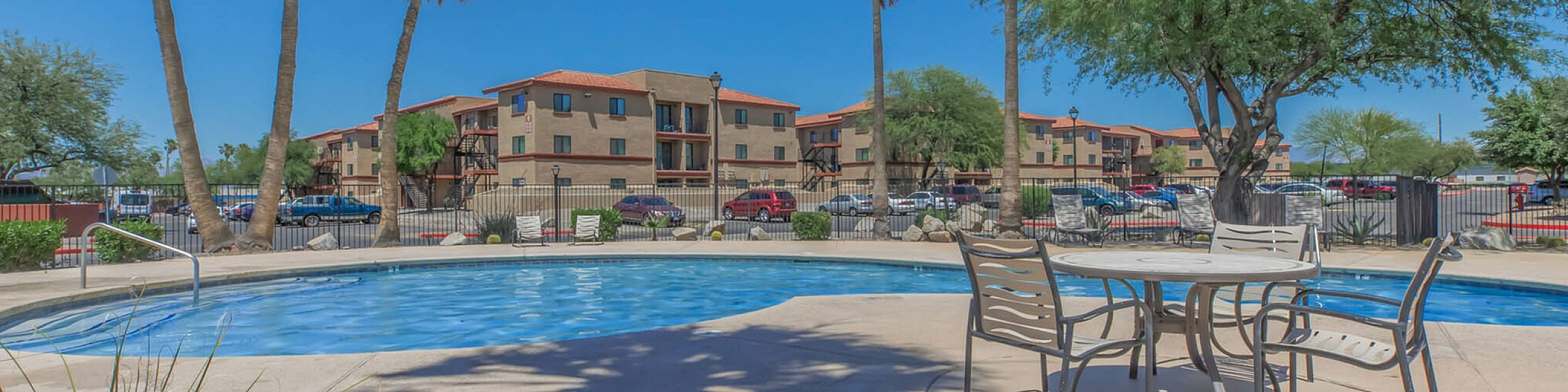 pool with picnic table and chairs and trees around