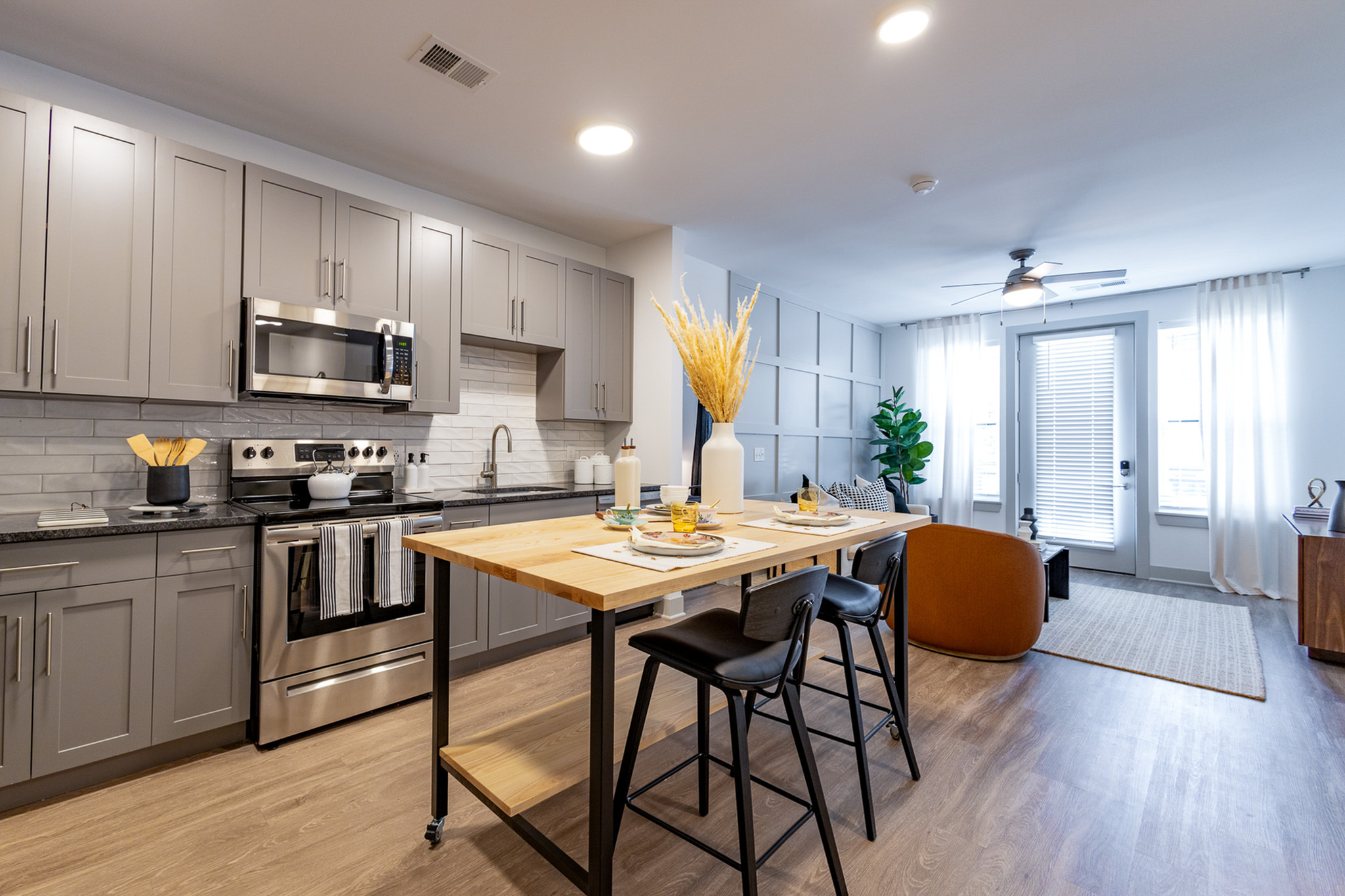 Open-concept Woodburn Exchange apartment with gray kitchen cabinetry and stainless-steel appliances
