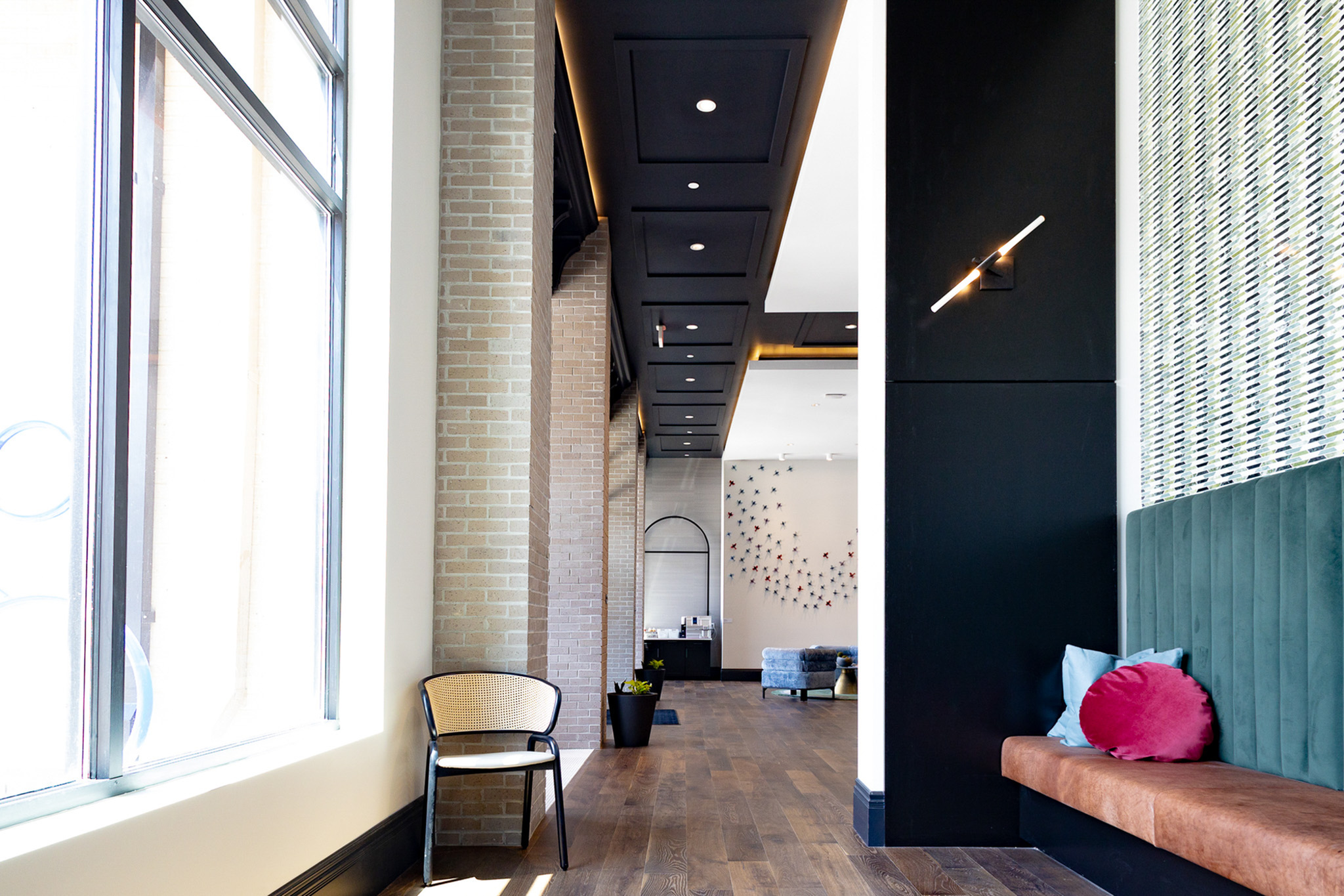 Design-forward resident interior with exposed brick and built-in seating at Woodburn Exchange