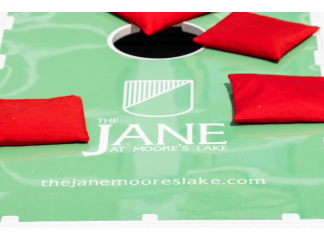 close up of green cornhole board with red bean bags