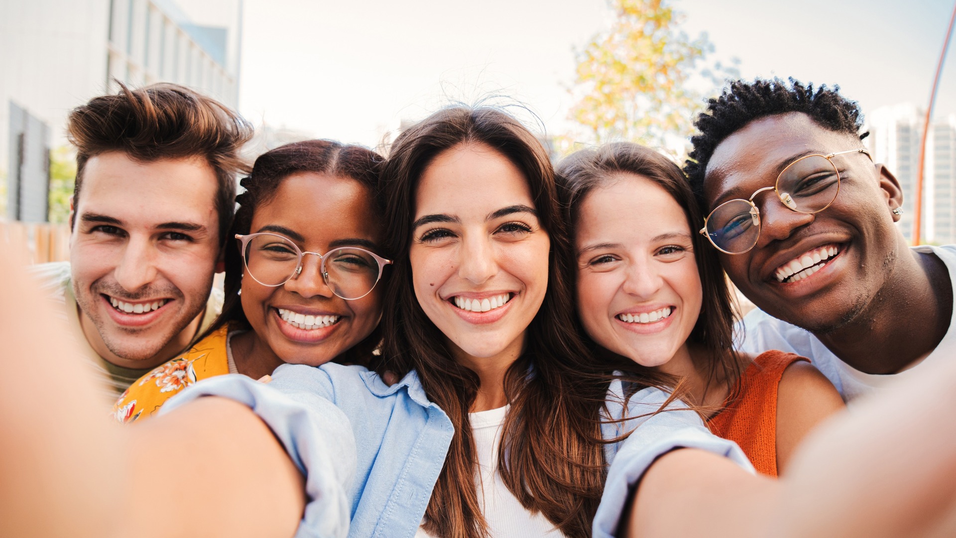 Group of happy friends smiling while taking selfie