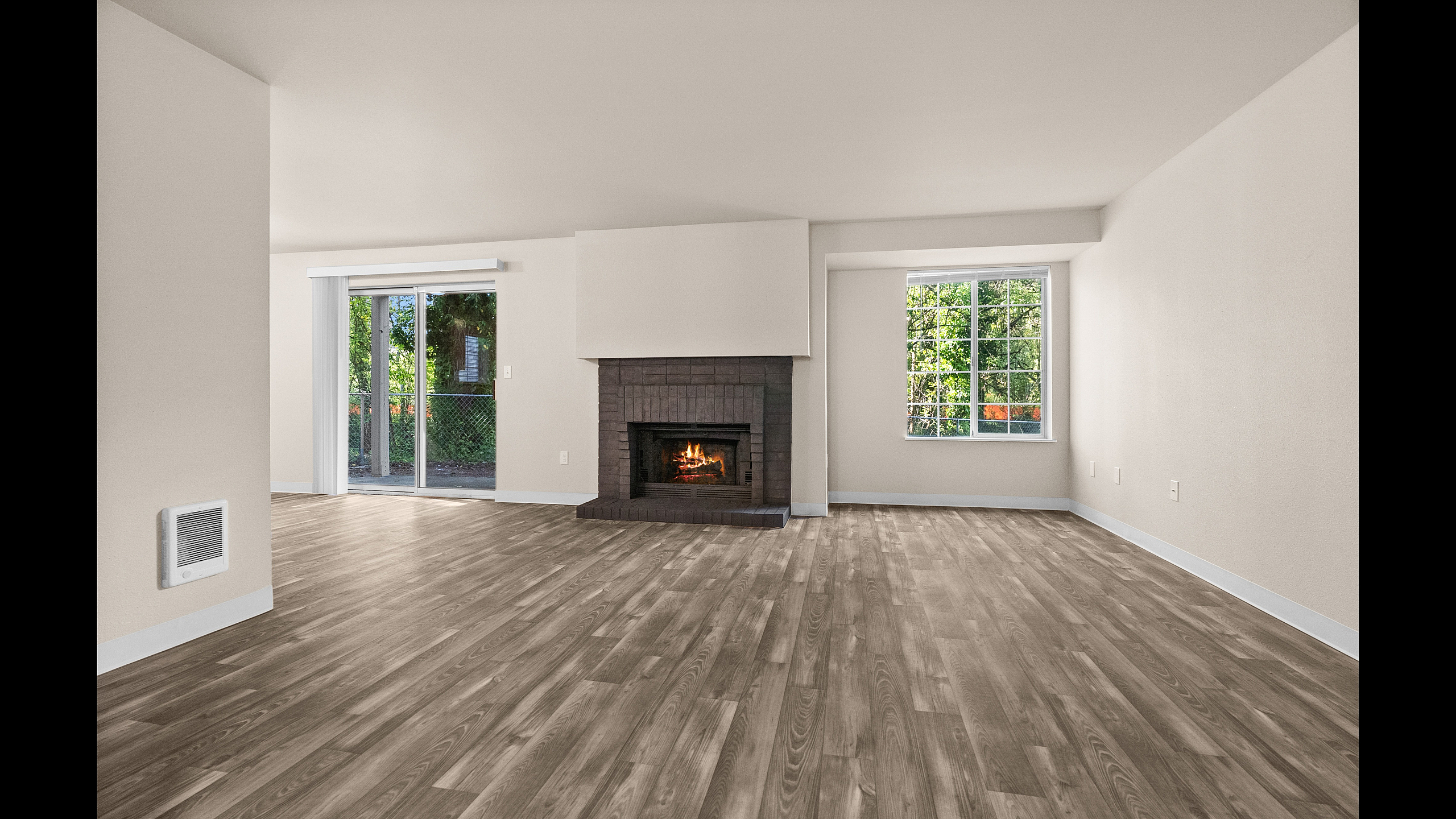 Inviting living room with elegant hardwood floors, a cozy fireplace, and abundant natural light through large windows.