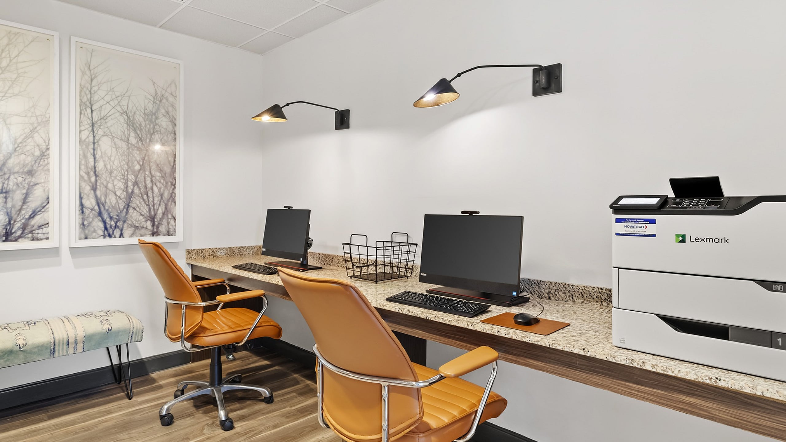 Modern 303 Flats communal workspace with sleek computers, stylish tan chairs, and a high-performance printer in a chic setting.