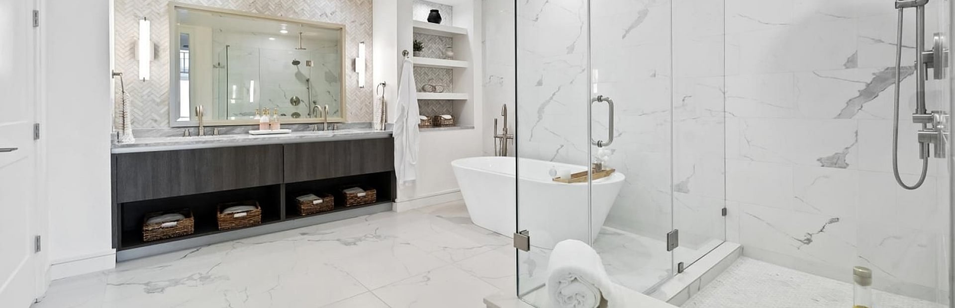 Luxurious modern bathroom with elegant double vanity, spacious glass shower, and a chic freestanding tub, accentuated by marble flooring and tasteful decor.