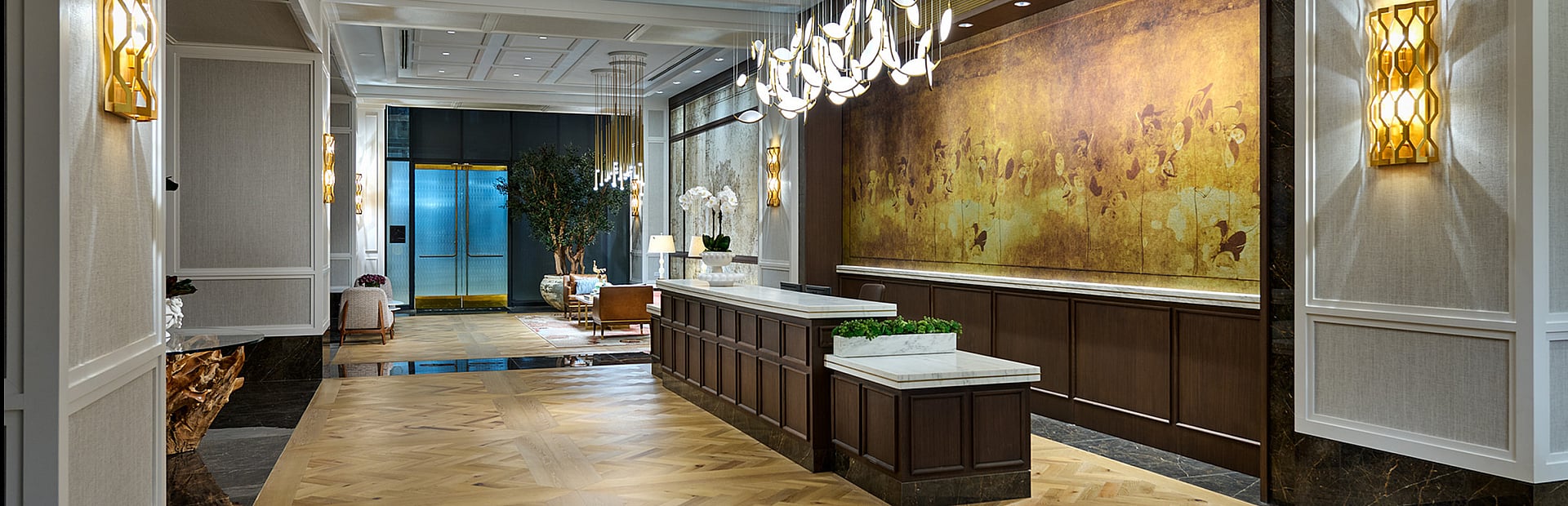 Luxurious hotel lobby with elegant chandeliers, stunning wall art, and warm ambient lighting.