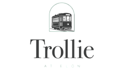 Elegant logo featuring a vintage trolley design above the bold word 'Trollie' with a refined and modern aesthetic.