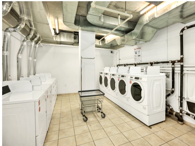 Arabella 101, interior, laundry facility, cart, white washers and dryers, tile floor, vent ducts