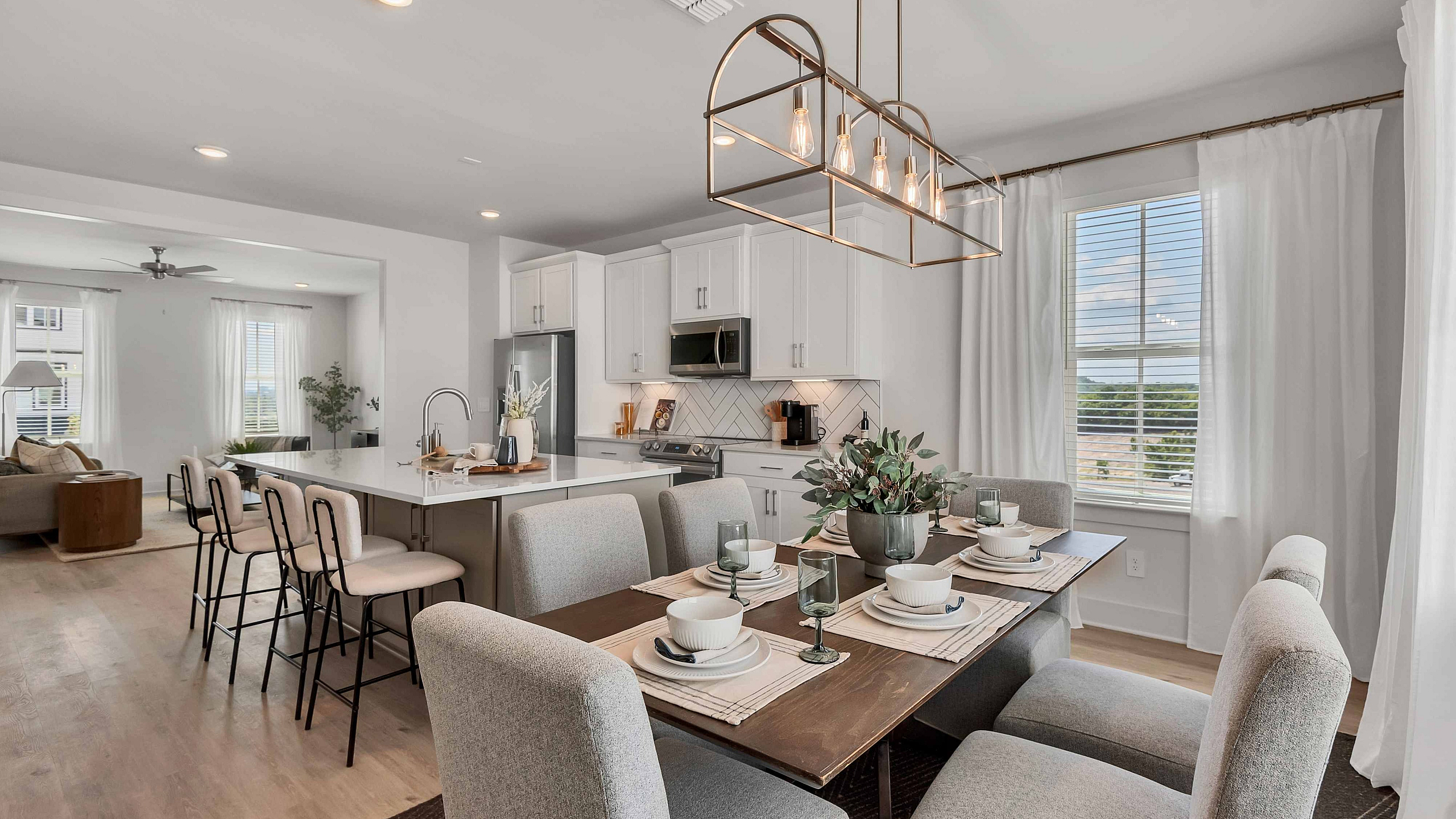 upscale decorated dining and kitchen areas with white cabinets and upgraded lighting